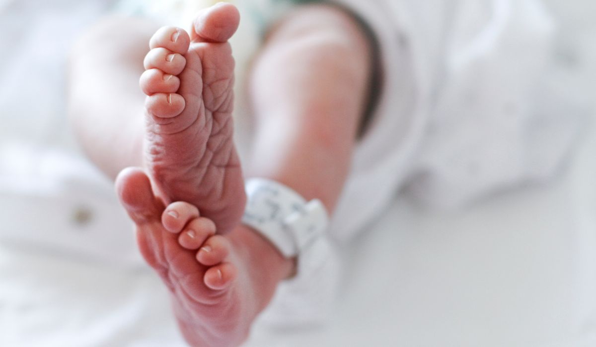 Newborn baby's feet with hospital bracelet around ankle