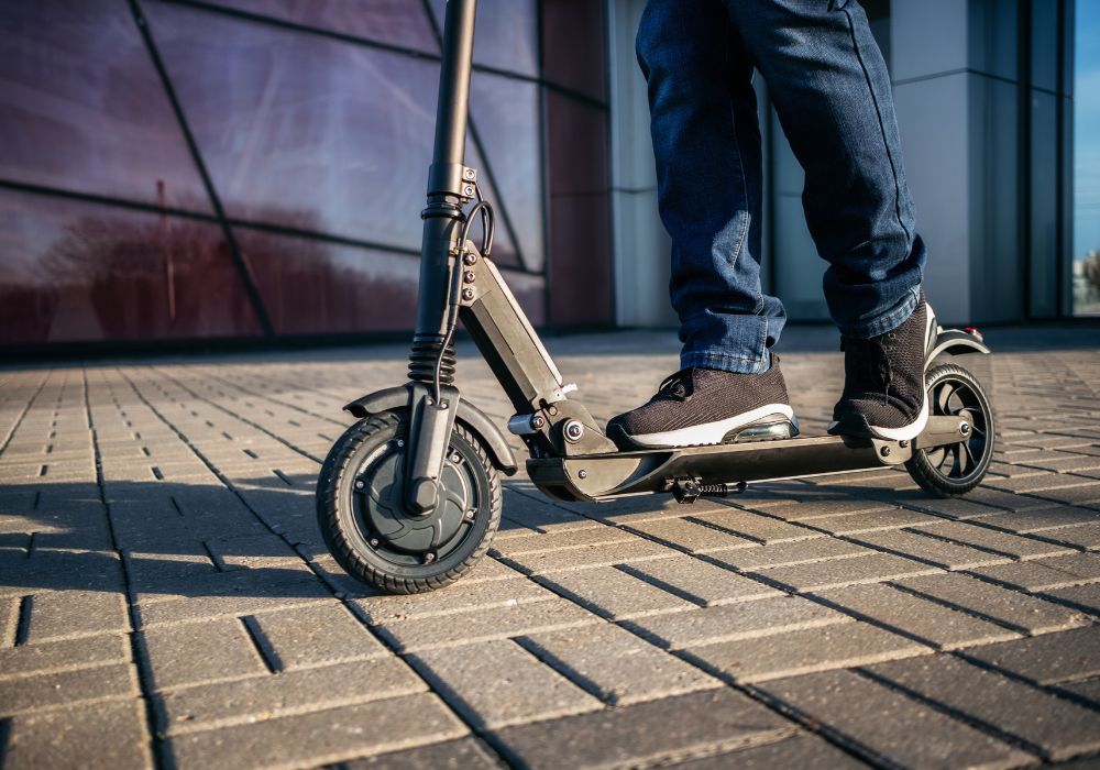 Teenager riding e-scooter on footpath