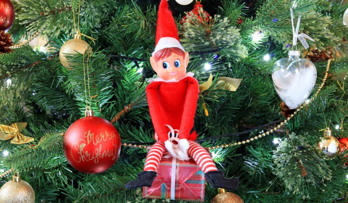 Elf on the Shelf sitting on the Christmas tree