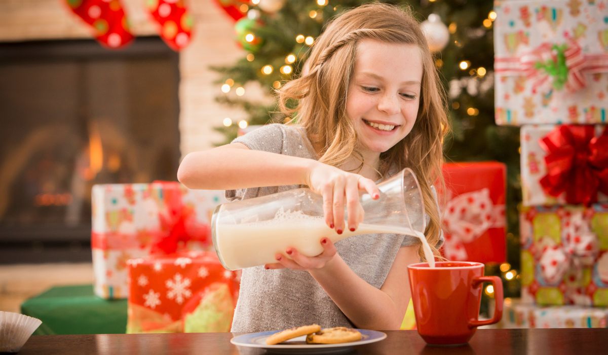 Girl pouring out milk and a treat for Santa