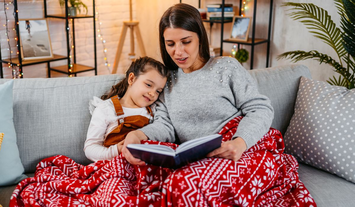 Mother reading her daughter a Christmas story