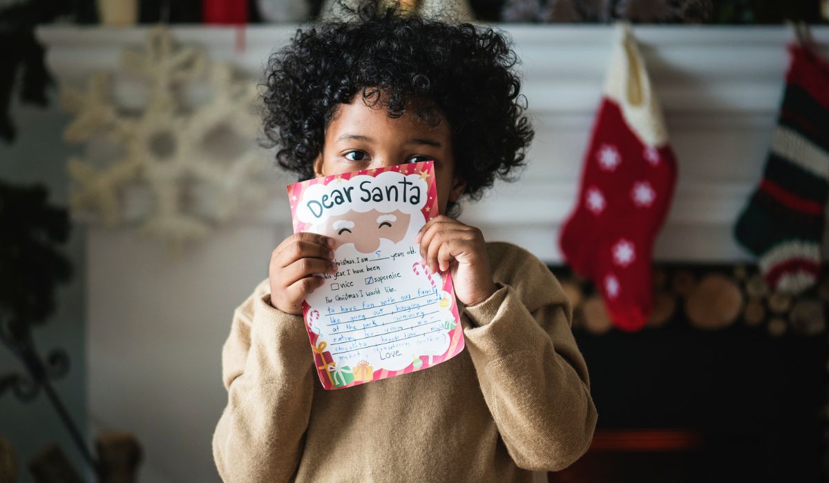 Little boy holding up his letter to Santa
