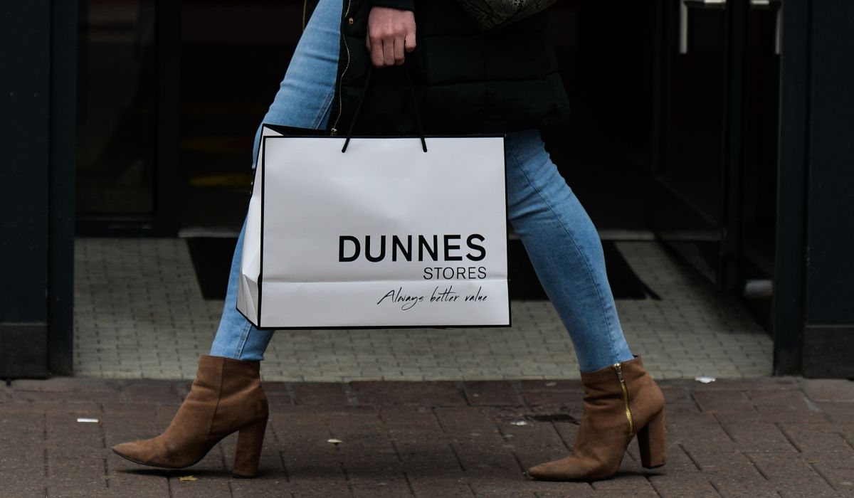 A woman walking with a Dunnes bag