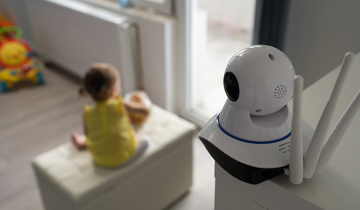 Surveillance camera baby monitor at home monitoring small child while playing in room childhood family protection parenthood concept