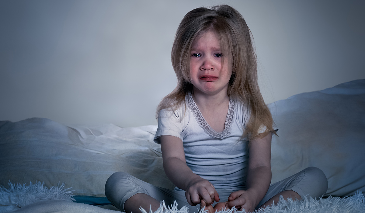 The baby is crying. A little girl in bed for the night