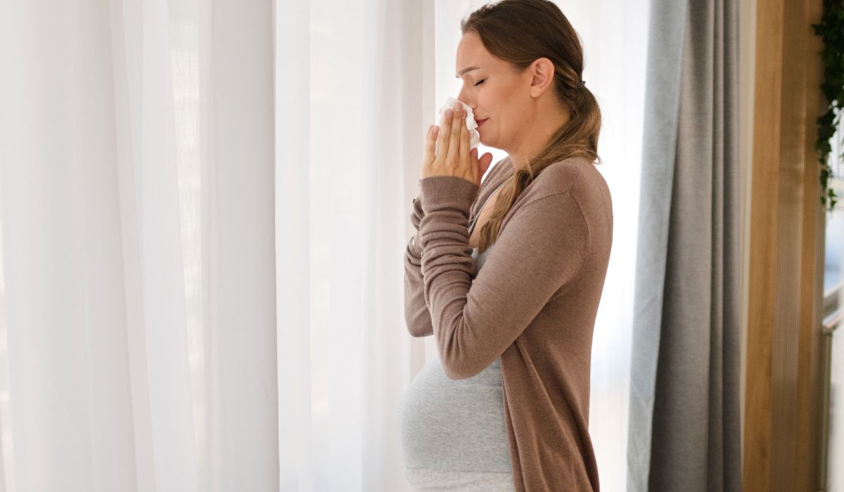 Pregnant woman blowing nose