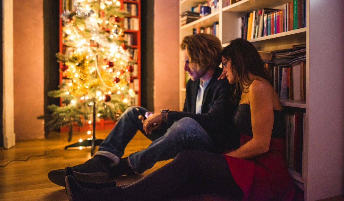 Sad couple sitting in front of Christmas tree