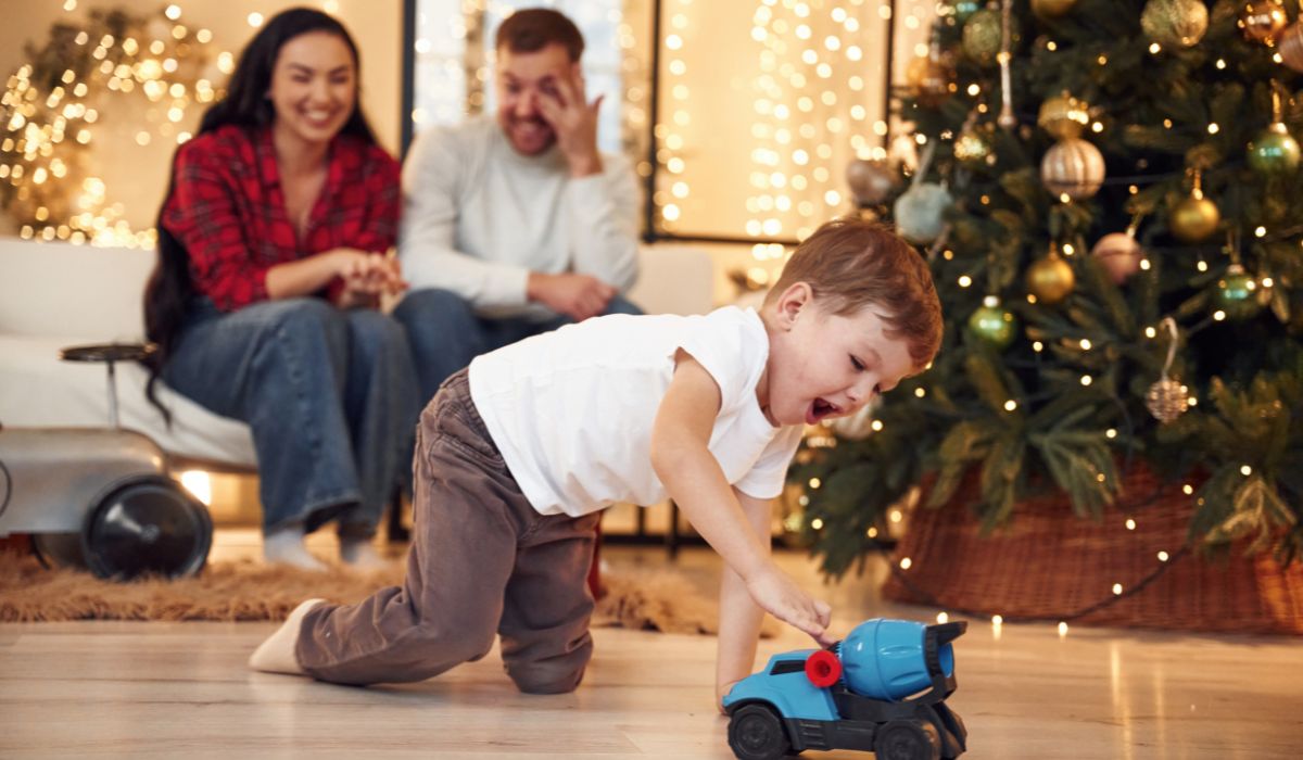 Family at Christmas with boy playing with a car