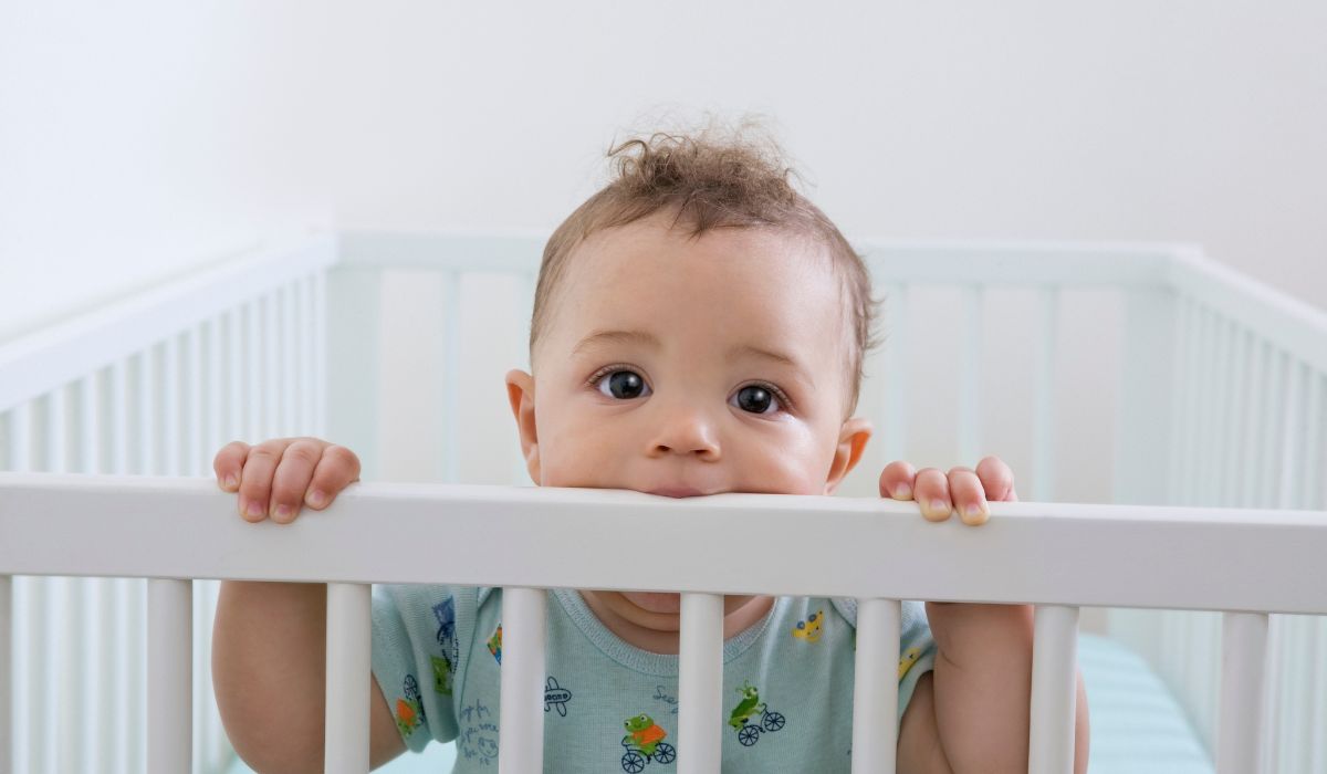 Baby peeping out from it's cot