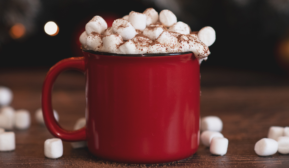 Christmas cocoa header with marshmallows, chocolate crumbs, and syrup. Large coffee cup with homemade hot chocolate. Pic: Getty Images