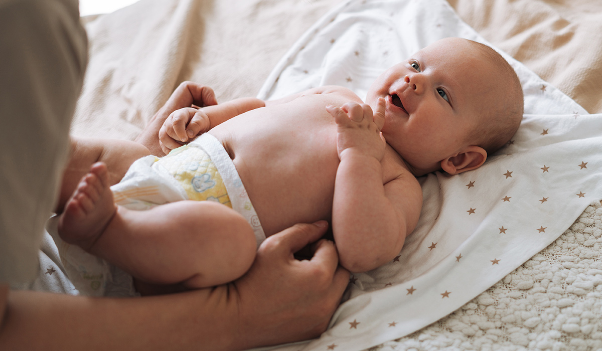Adult woman young mother with 2-3 month baby boy lying on white blanket at home. Pic: Getty Images