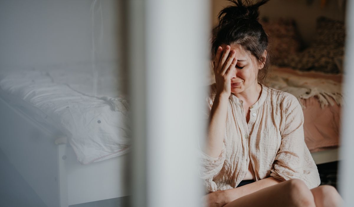 Woman crying in bedroom