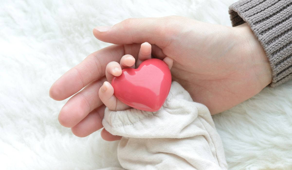 Baby holding heart