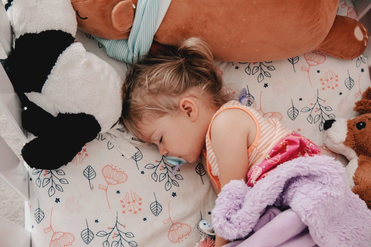 Toddler asleep in cot
