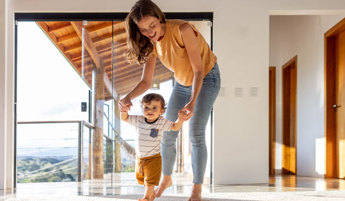 Mother helping baby learn to walk