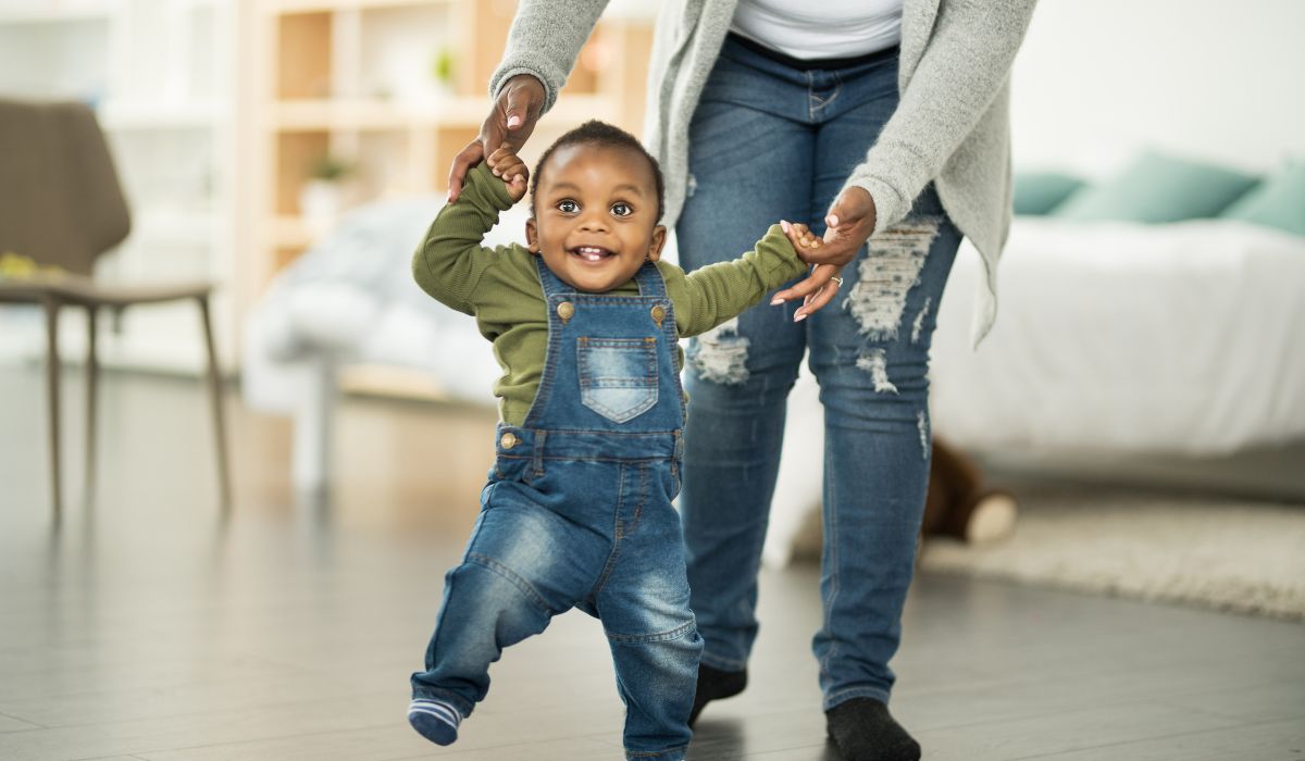 Mother helping baby learn to walk
