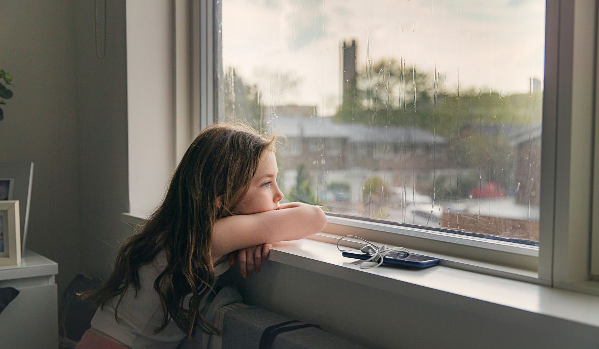 Sad girl looking out window