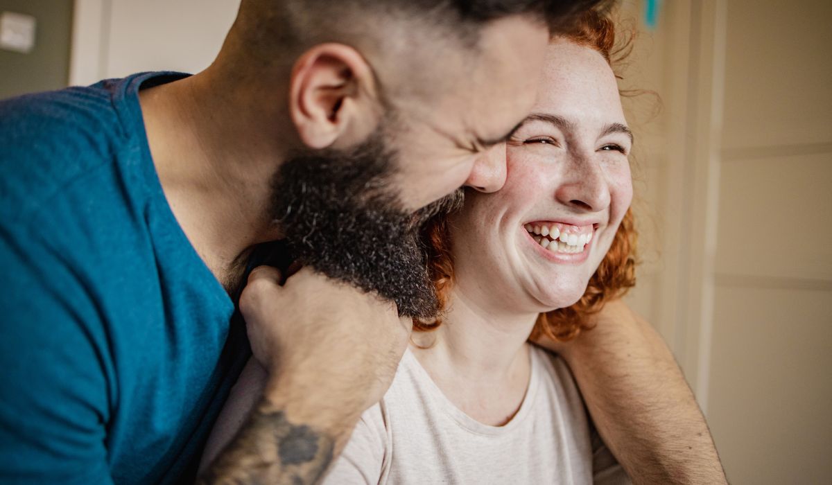 Man whispering in woman's ear