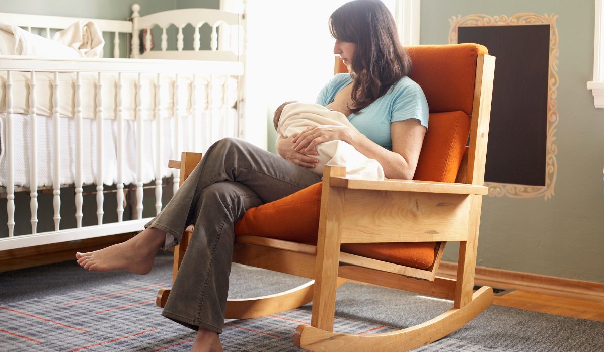 Woman sitting in a rocking chair breastfeeding her baby