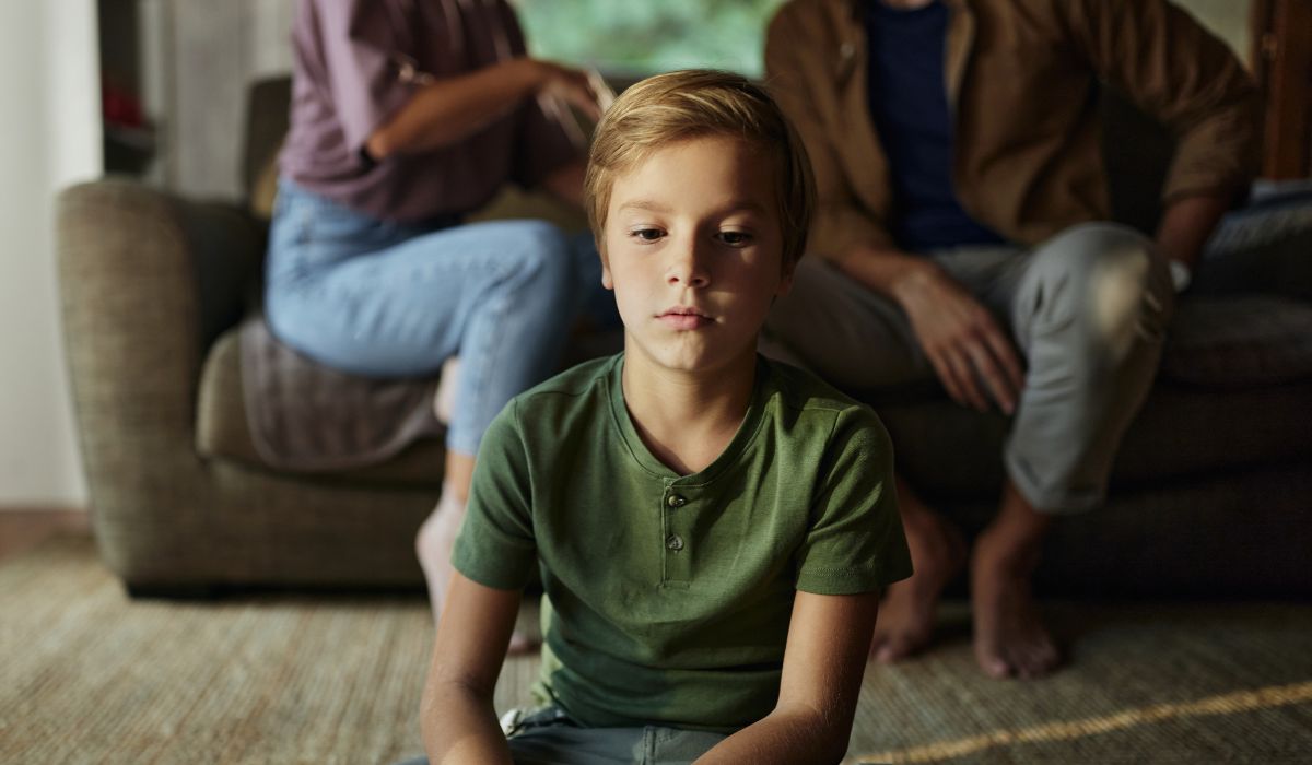 Parents speaking in background, child in front