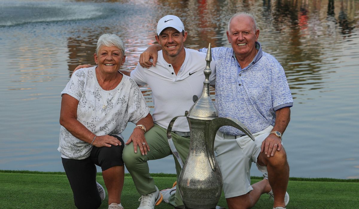 Rory McIlroy of Northern Ireland laughs with his parents, Rosie and Gerry McIlroy as they pose with the trophy after the Final Round of the Hero Dubai Desert Classic