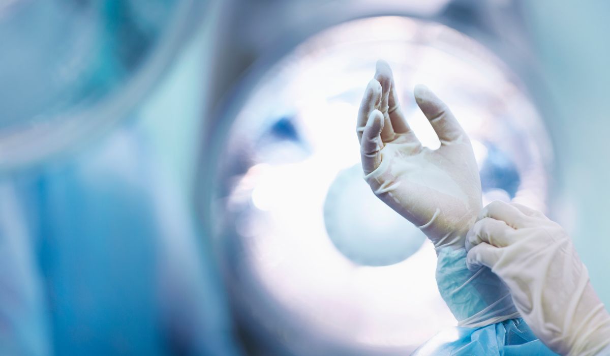 Surgeon putting on glove