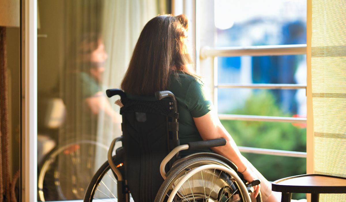 Woman in wheelchair looking out window