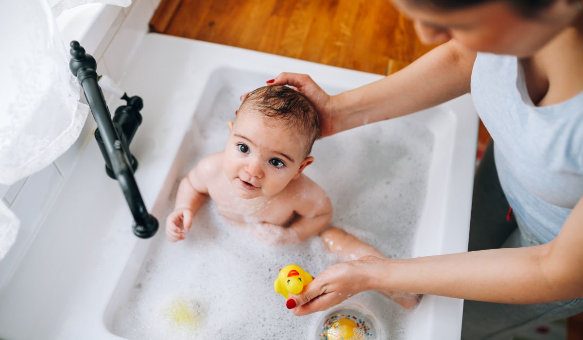 Baby being bathed in the sink
