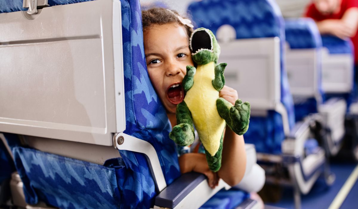 Child on a plane playing with a dinosaur