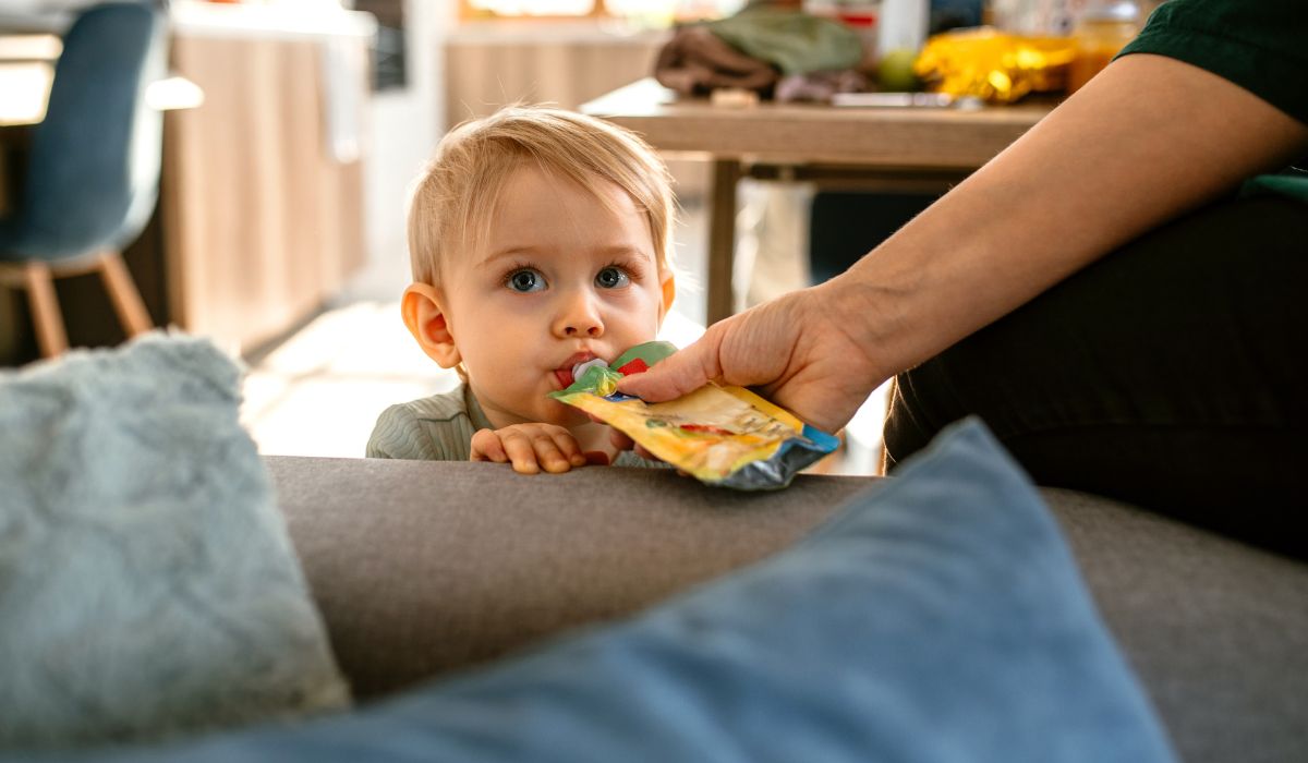 Parent feeding baby food from pouch