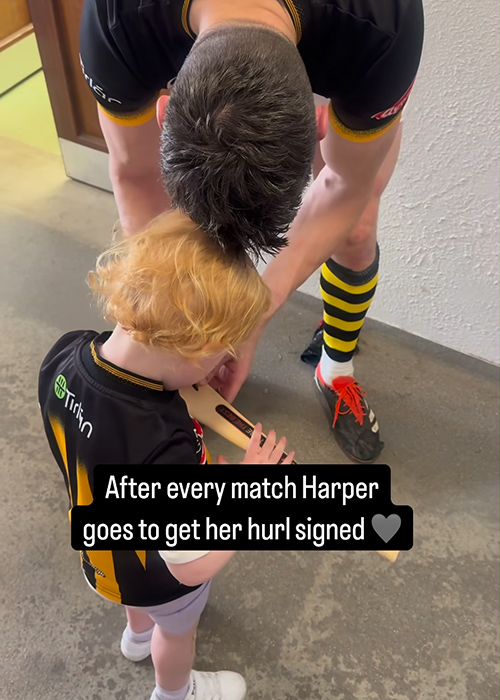 TJ Reid signs his daughter Harper's hurl. Pic: Niamh de Brún / Instagram