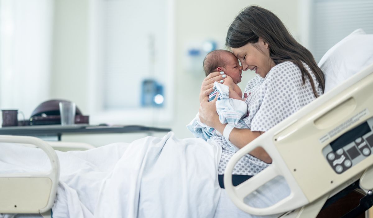 Mum holding her baby in her hospital bed
