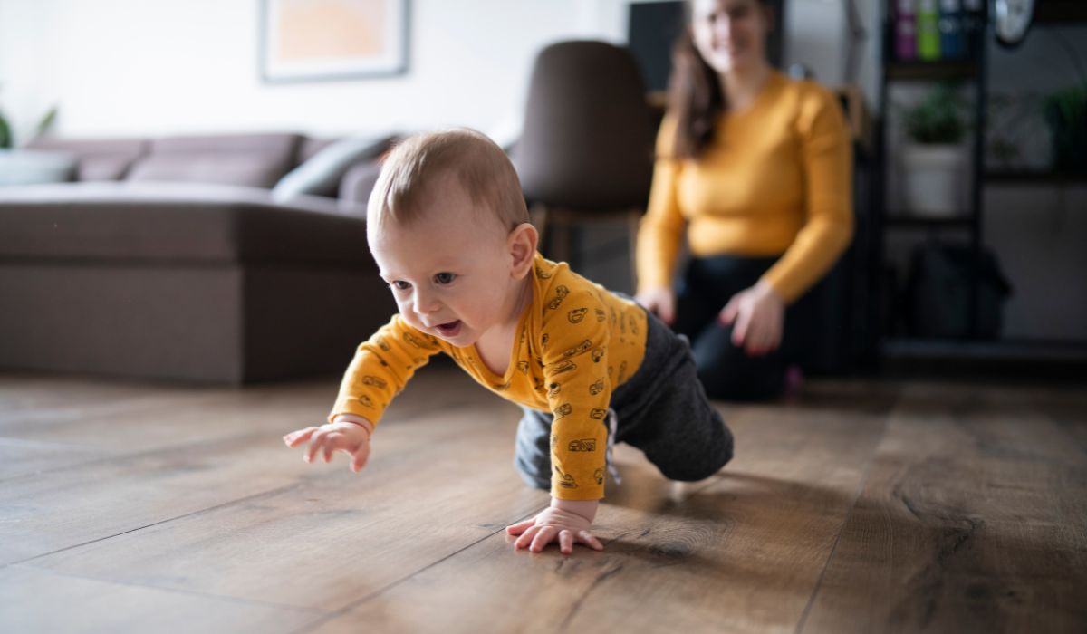 Baby crawling with his mum watching