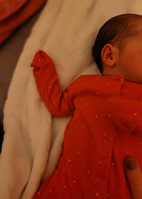 Newborn in a red babygrow