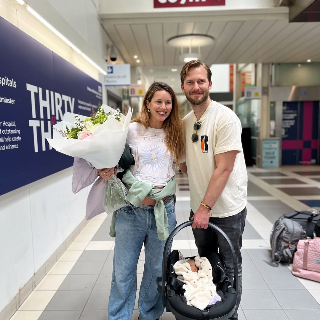 Caggie Dunlop leaving hospital with her newborn baby and partner