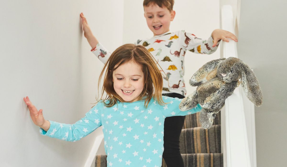Kids in pajamas running down the stairs