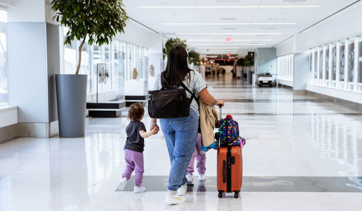Mother and child in airport with hand luggage
