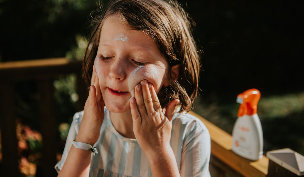 Child applying sunscreen