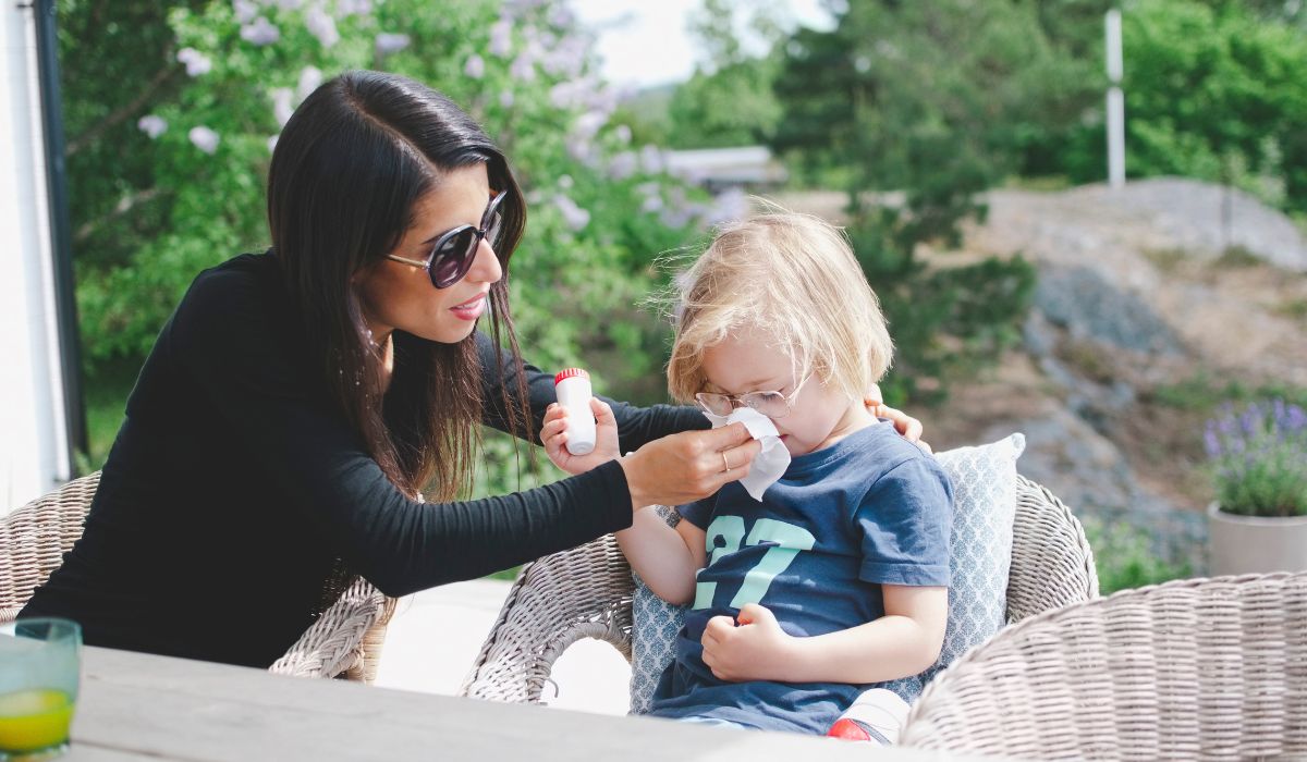 Mother helping child blowing nose