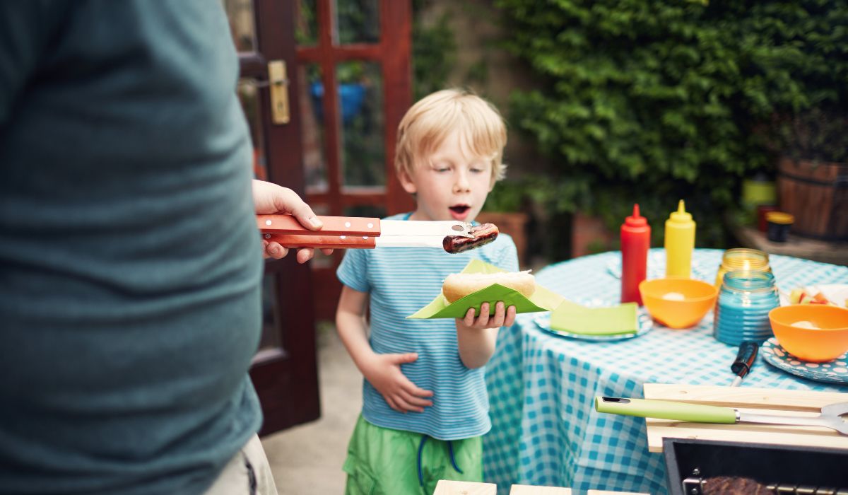 Dad giving son hotdog