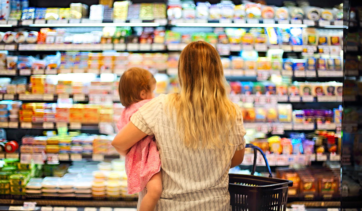 Cheerful mother and baby spending time in shopping in supermarket