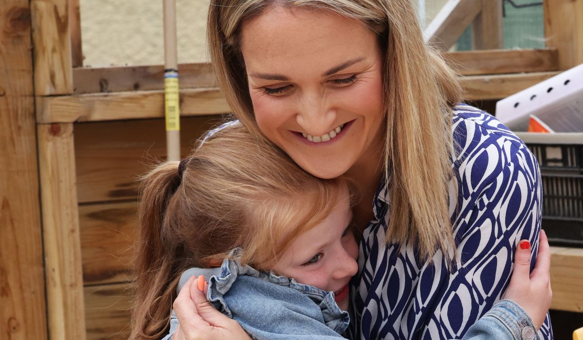 Minister for Education and Youth Helen McEntee TD gets a hug from Isa McKenna 7yrs as she met with children participating in the Summer Programme 2025 on a visit to St Marys Junior NS, Rowlagh, Clondalkin, Dublin 22.