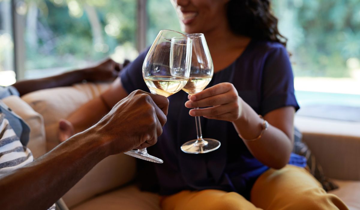 Two people clinking win glasses