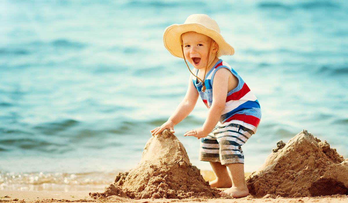Child at the beach wearing a hat