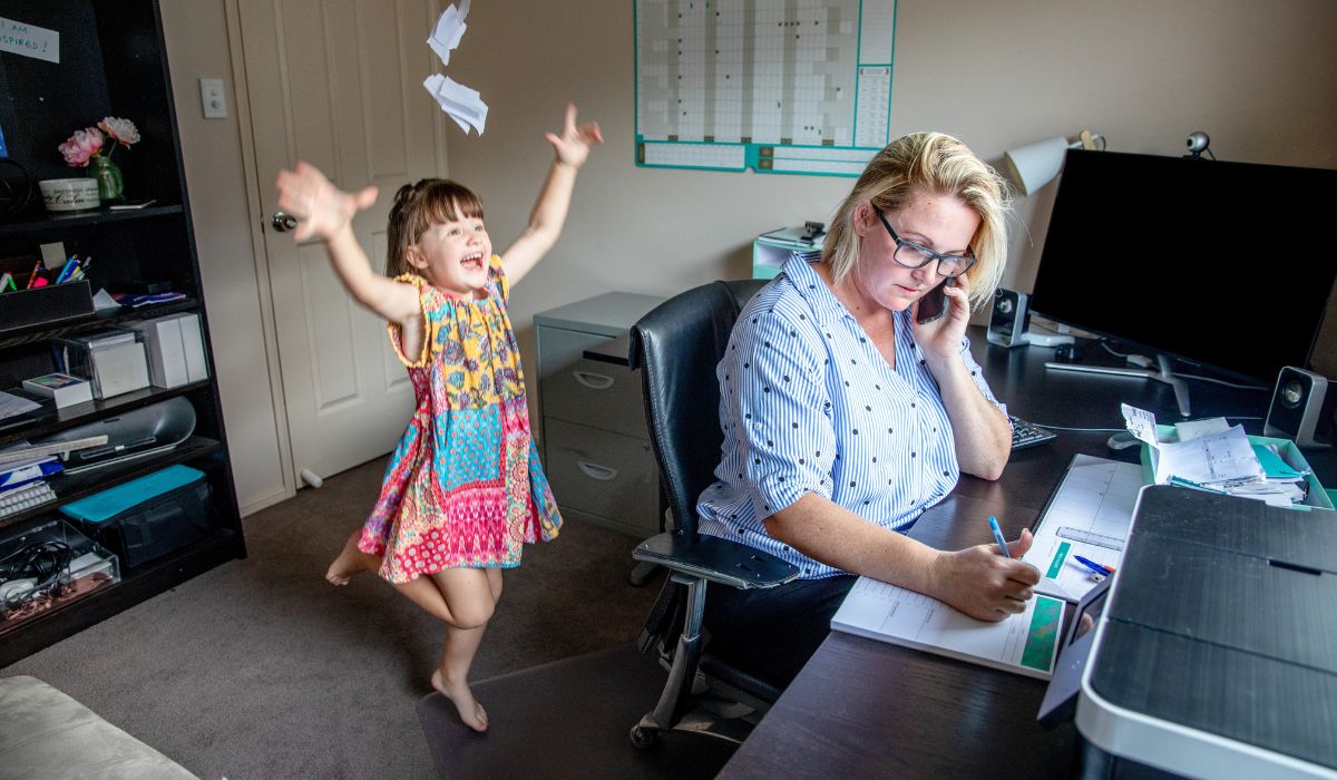 Mother trying to work from home while her child plays