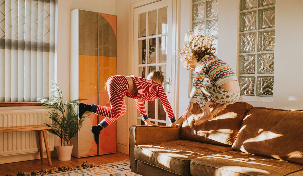 Kids jumping on the couch at home