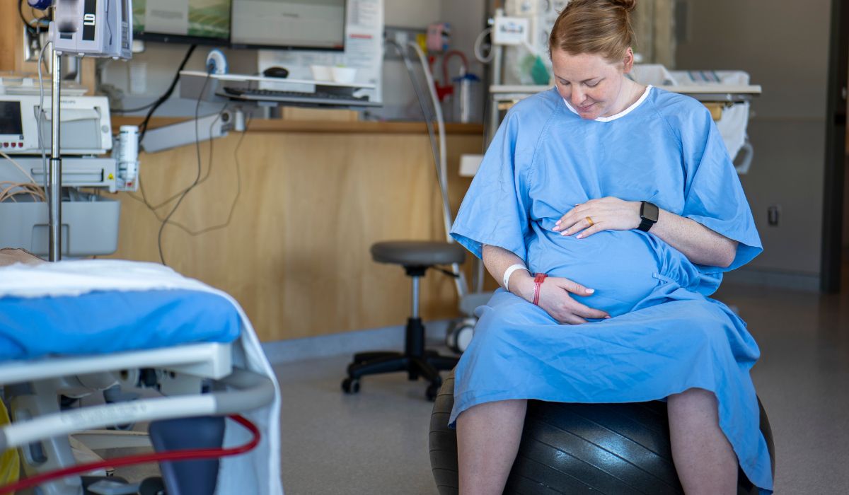 Woman sitting on birthing ball in hospital