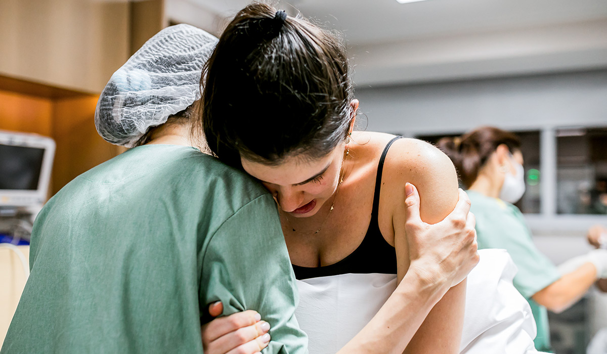 Doula helping pregnant women during birth at hospital