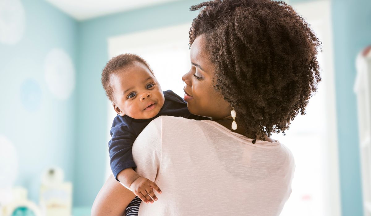 Mother holding newborn over shoulder