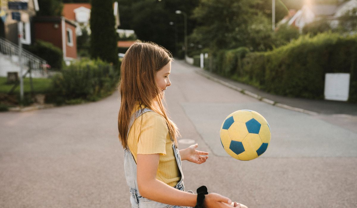Young girl playing with football